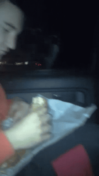 Blurry Person Eating Sandwich In Car GIF