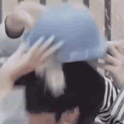 Blurry Person Holding Blue Object GIF