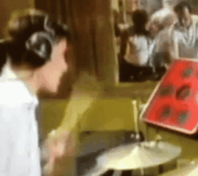 Blurry Person Playing Drum Set With Headphones GIF
