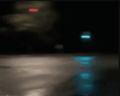 Blurry Person Riding Bike Down Street At Night GIF