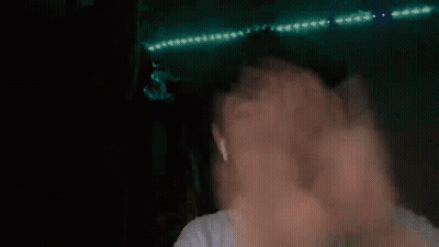 Blurry Person's Face And Hands With Green Lights GIF