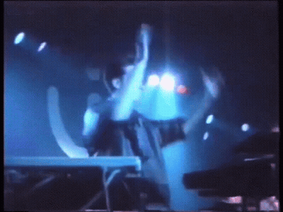 Blurry Person Standing In Front Of Blue Light GIF