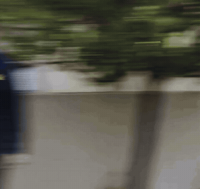 Blurry Person Walking Along Sidewalk GIF