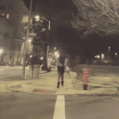 Blurry Person Walking On Sidewalk At Night GIF