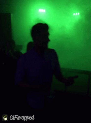 Blurry Picture Of Man Dancing In Front Of Green Background GIF