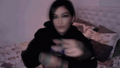 Blurry Woman Laying On Bed In Black Hoodie Saying Purple GIF