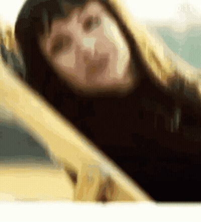 Blurry Woman Laying On Bed Looking At Camera GIF