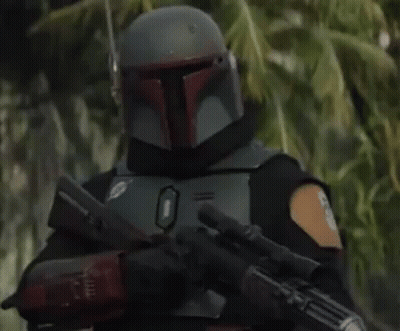 Boba Fett Is Wearing A Helmet And Holding A Gun In A Forest . GIF