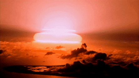 Bomb Explosion Illuminates The Horizon At Dusk GIF