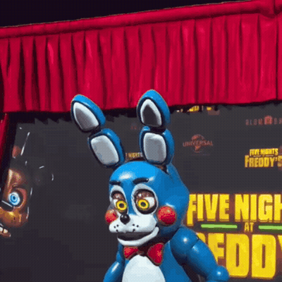 Bonnie The Bunny From Five Nights At Freddy's Standing In Front Of Red Curtain And Poster GIF