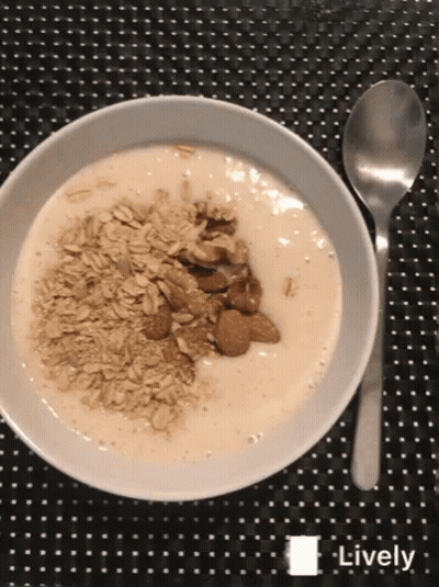 Bowl Of Yogurt With Oatmeal And Almonds Next To Spoon GIF