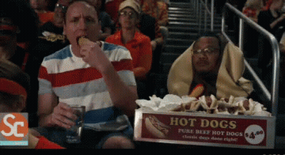 Box Of Hot Dogs On Table In Front Of Crowd GIF