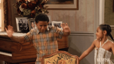 Boy and Girl Dancing in Living Room With Netflix Logo
