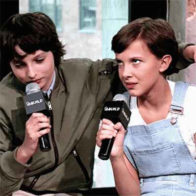 Boy And Girl Holding Microphones Saying Build GIF