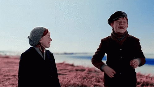 Boy And Girl In Field Of Pink Grass GIF