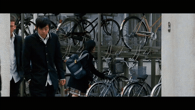 Boy And Girl Walking Past Bikes GIF