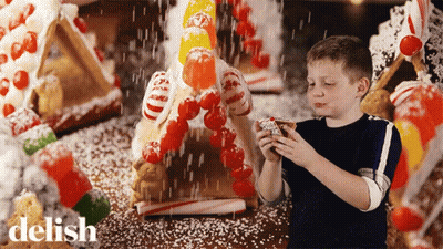 Boy Decorating Gingerbread House With Candy Canes GIF