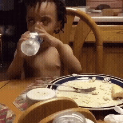 Boy Drinking Water From Bottle At Table With Food GIF