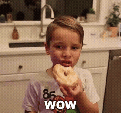 Boy Eating Donut With Wow Shirt GIF