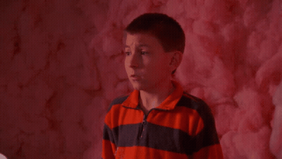 Boy Eating Pink Cotton Candy In Front Of Pink Wall GIF