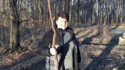 Boy In Black Jacket Holding Tree Branch GIF