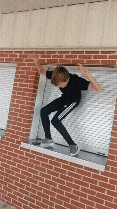 Boy In Black Shirt Jumping Over Window GIF