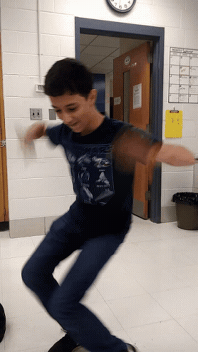 Boy In Blue Shirt Jumping Before Clock GIF