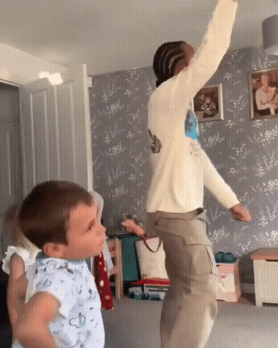 Boy In Blue Shirt Next To Jumping Man GIF