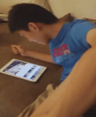 Boy In Blue Shirt Playing On Tablet GIF
