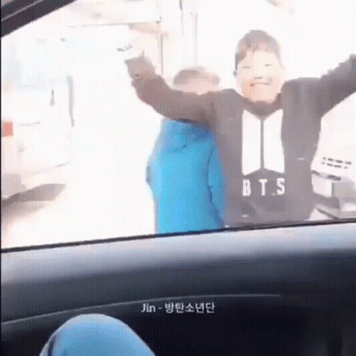 Boy In BTS Shirt Sitting In Car With Arms Up GIF