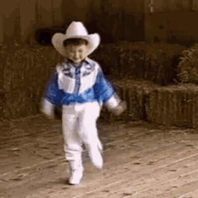 Boy In Cowboy Hat Walking On Wooden Floor GIF