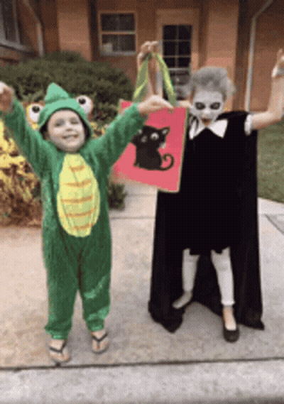 Boy In Frog Costume And Girl In Black Cat Costume GIF