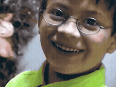 Boy In Glasses And Neon Green Shirt Smiling GIF