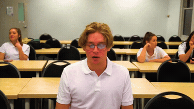 Boy In Glasses With Mouth Open In Classroom GIF
