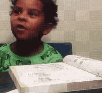 Boy In Green Shirt Holding Book GIF