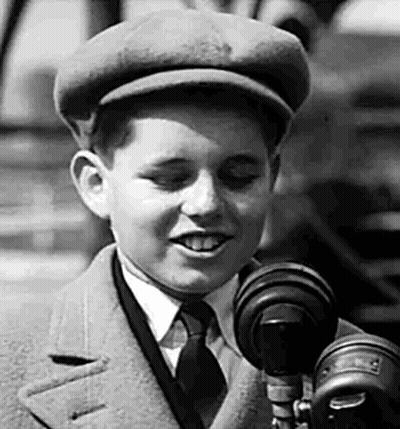 Boy In Hat And Tie Talking Into Microphone GIF