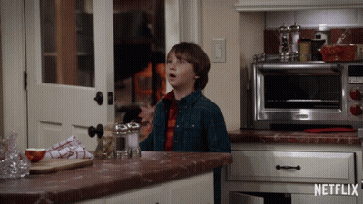 Boy In Kitchen With Netflix Logo On Counter GIF
