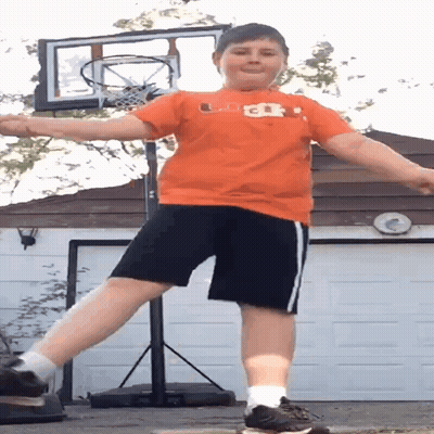 Boy In Orange Shirt And Black Shorts At Basketball Net GIF
