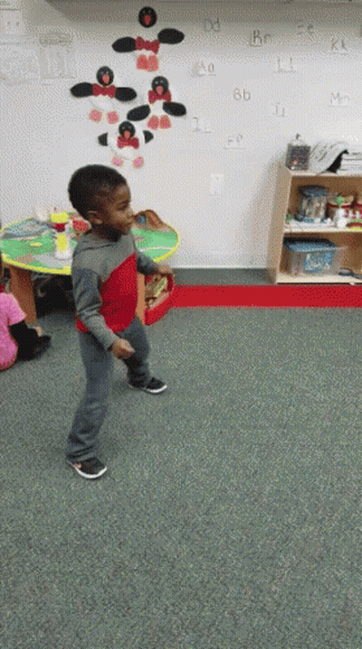 Boy In Red Shirt Dancing In Front Of Alphabet Wall GIF