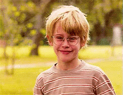 Boy In Striped Shirt And Glasses Smiling In Park GIF