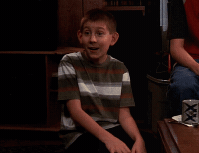Boy In Striped Shirt Sitting In Front Of XXX Can GIF