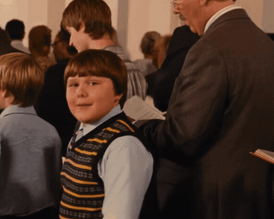 Boy In Striped Vest Standing In Crowd GIF
