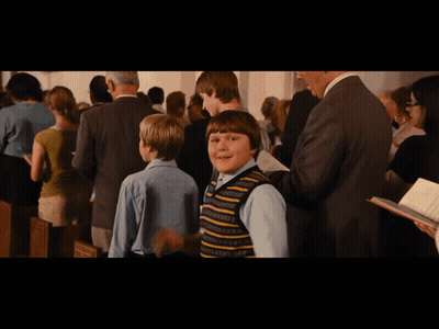 Boy In Striped Vest Standing In Crowd GIF