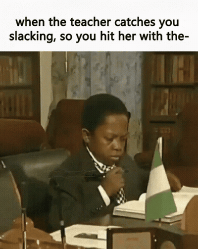 Boy In Suit And Tie Sitting At Desk With Book And Flag GIF