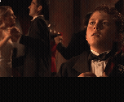 Boy In Tuxedo Standing In Front Of Hold On A Second Guys Sign GIF
