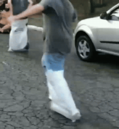 Boy In White Shirt And Black Shorts Walking On Brick Walkway GIF