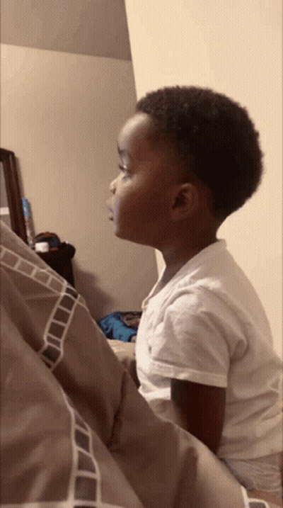 Boy In White Shirt Sitting On Bed GIF