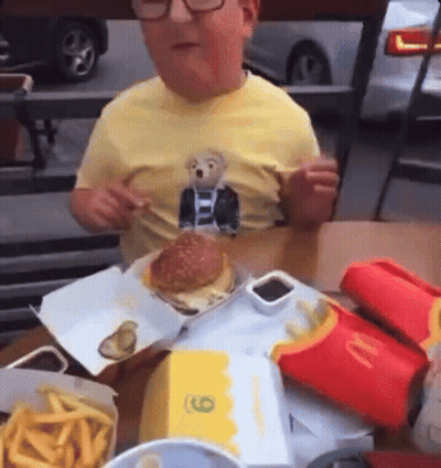 Boy In Yellow Shirt Eating Hamburger At McDonald's GIF