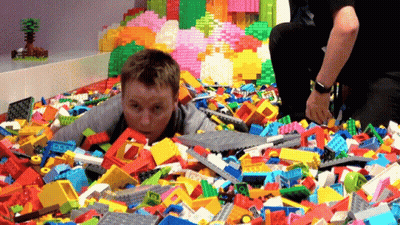 Boy Lying In Lego Bricks GIF