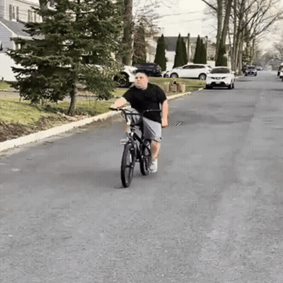 Boy Riding Bike Down Street GIF